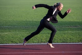 business woman in start position ready to run and sprint on athletics racing track.jpeg